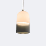 Pharos Pendant Light by Cerno - hand-blown white and bronze gradient glass with brushed brass metal finish and taupe cloth cord, lit