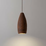 Seth Ceramic Pendant Light by Geo Contemporary in Cinnamon, lit against a grey studio wall