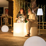 Tafy Side Table - White, on a lit terrace