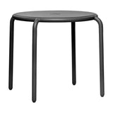 Round anthracite metal outdoor dining table with curved tubular legs and a central cap — Toní Bistreau outdoor dining table by Fatboy