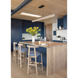 Una Linear Pendant by Cerno over a kitchen island with wood ceiling