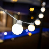 Bruna Solar String Lights - lit by a pool at night