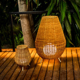 Saona Floor Lamp - lit on a deck beside the table lamp