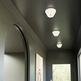 Holt Ceiling Light by Kuzco - Large, Brushed Gold/Glossy Opal Glass fixed on ceiling in corridor